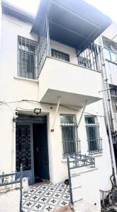 ein weißes Gebäude mit einer schwarzen Tür und einem Balkon in der Unterkunft Taksim apartment in Istanbul