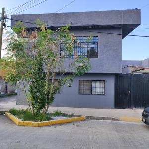 a blue building with a tree in front of it at Bonito departamento in Morelia