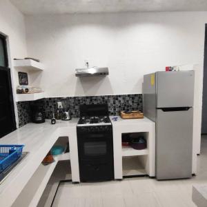 a small kitchen with a stove and a refrigerator at Bonito departamento in Morelia