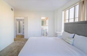 a white bedroom with a large bed and windows at Luxury 2 Bedroom 2 Bathroom Residence Green Park View in Los Angeles