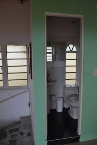 La salle de bains est pourvue de toilettes blanches et d'une fenêtre. dans l'établissement Finca con billar y piscina para un Descanso Familiar, à Pereira