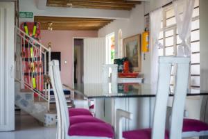une cuisine avec une table en verre et deux chaises blanches dans l'établissement Finca con billar y piscina para un Descanso Familiar, à Pereira