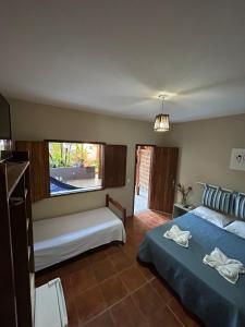 a bedroom with two beds and a large window at Itaoca Pousada in Itacaré