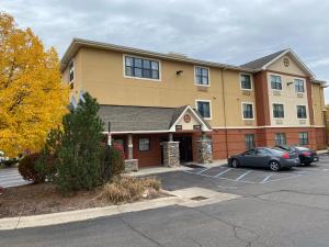 un edificio con coches estacionados en un estacionamiento en Suburban Studios, en Auburn Hills