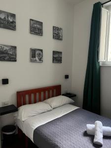 1 cama en un dormitorio con cuadros en la pared en Domus Romana, en Roma
