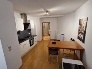 a kitchen and dining room with a wooden table in it at City Central Apartment in Kaiserslautern