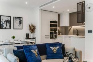 a living room with a couch and a kitchen at Chic Chelsea 1BR Luxe Retreat, Serene Balcony in London