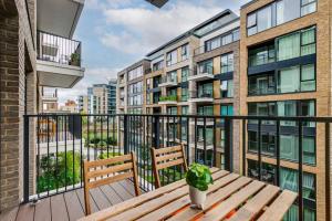 a balcony with a wooden table and a potted plant at Chic Chelsea 1BR Luxe Retreat, Serene Balcony in London