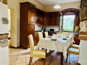cocina con mesa de comedor y sillas amarillas en Villa Sissi, en Arliano