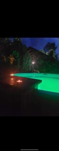 a view of a lake at night with green lights at Casa Perla Nordului in Moisei