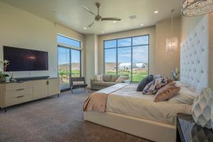 a bedroom with a large bed and a flat screen tv at Live Luxurious at Zion in Hurricane +63 photos