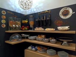a kitchen with plates and dishes on a shelf at Hotel Dover in Milan