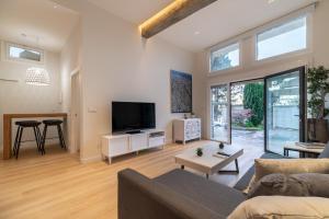 een woonkamer met een bank en een tv bij Loft Playa Samil in Vigo