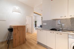 a kitchen with white cabinets and a counter top at Loft Playa Samil in Vigo