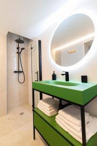 a bathroom with a green sink and a mirror at Loft Playa Samil in Vigo