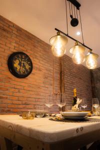 een tafel met wijnglazen en een klok op een stenen muur bij Édouard & Richard in Colmar