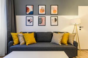 a living room with a blue couch with yellow pillows at Travelers Hideout - Central Apartment in Braşov