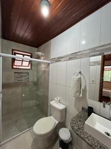 a bathroom with a toilet and a shower and a sink at Itaoca Pousada in Itacaré