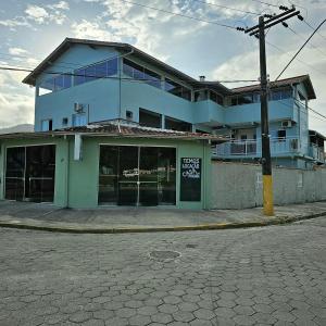 ein blaues Gebäude mit einem Schild davor in der Unterkunft Pousada Suíte Verde Mar in Ubatuba