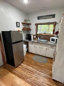 uma cozinha com um frigorífico de aço inoxidável e um lavatório em Treehouse at Berry-patch em Longview