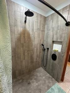 y baño con ducha y pared de azulejos. en Treehouse at Berry-patch, en Longview