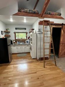 uma cozinha com uma escada ao lado de um frigorífico em Treehouse at Berry-patch em Longview