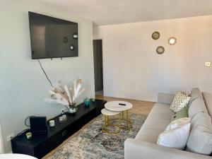a living room with a couch and a tv on the wall at New ATL Dwntwn Condo with Balcony 2 in Atlanta