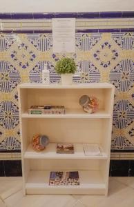 a white shelf with a plant on a wall at BBTK Bed and Bike in Málaga