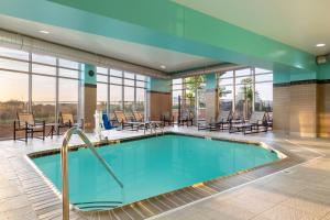 uma piscina no átrio do hotel com mesas e cadeiras em Spring Hill Suites Minneapolis-St. Paul Airport/Mall Of America em Bloomington