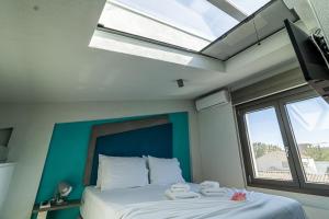 a bedroom with a bed with a large window at STREET 90 LuX APARTS in Keramotí +68 photos