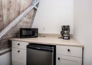 una cucina con forno a microonde e macchinetta del caffè su un bancone di ROOM 04 - Lake Sumner a Clermont