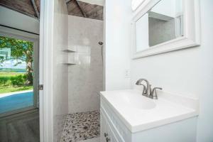 bagno bianco con lavandino e specchio di ROOM 04 - Lake Sumner a Clermont