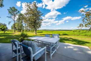 a table and chairs on a patio with a view of a field at ROOM 04 - Lake Sumner in Clermont