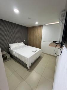 1 dormitorio con 1 cama blanca en una habitación en Bello Horizonte Plaza - Apartamento, en Santa Marta