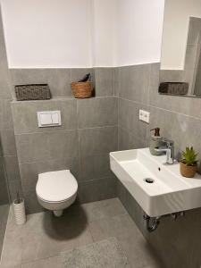 a bathroom with a white sink and a toilet at Große Apartments für Monteure & Feriengäste in Dorsten