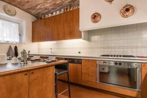 una cucina con armadi in legno e piano cottura di VillaColdiLunaProseccoHills 