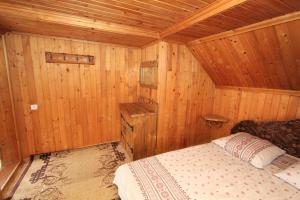 um quarto com uma cama num chalé de madeira em Садиба "Svitlana" em Yablunytsya