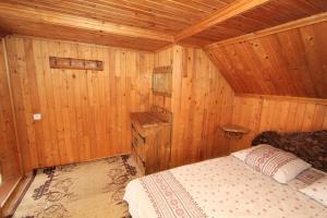 a bedroom with a bed in a wooden cabin at Садиба "Svitlana" in Yablunytsya +21 photos