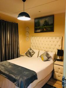 um quarto com uma cama grande e uma colcha branca em Ekhaya Sun Villa em Richards Bay