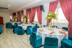 une salle de conférence avec des tables et des chaises bleues dans l'établissement SANA Hotel, à Abidjan