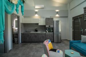 a living room with a blue couch and a kitchen at STREET 90 LuX APARTS in Keramoti