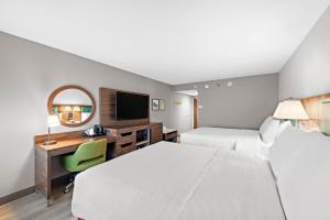 a hotel room with two beds and a desk at Hampton Inn Los Angeles Airport in Los Angeles