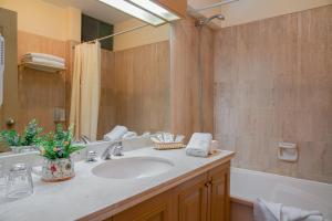 a bathroom with a sink and a tub and a mirror at Hotel Jose Antonio Puno in Puno