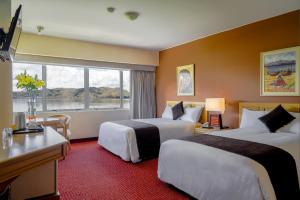 a hotel room with two beds and a window at Hotel Jose Antonio Puno in Puno