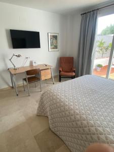 - une chambre avec un lit, un bureau et une télévision dans l'établissement APARTAMENTO SAN JOSE, à Palma del Río