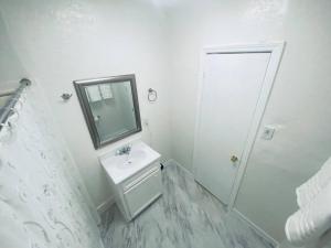 a white bathroom with a sink and a mirror at Holistic Gem w/1Gig Wi-Fi & free parking in Houston