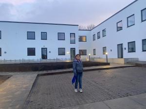 a woman standing in front of a white building at Quantum dimension in Rødovre
