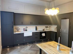 a kitchen with dark blue cabinets and a wooden table at No.8 Laura Place in Aberystwyth