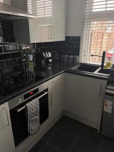 a kitchen with a stove top oven and a sink at Eden Stays in Stivichall