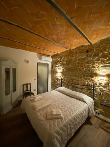 1 dormitorio con 1 cama grande en una pared de ladrillo en piccolo Garibaldi appartamento en Arezzo